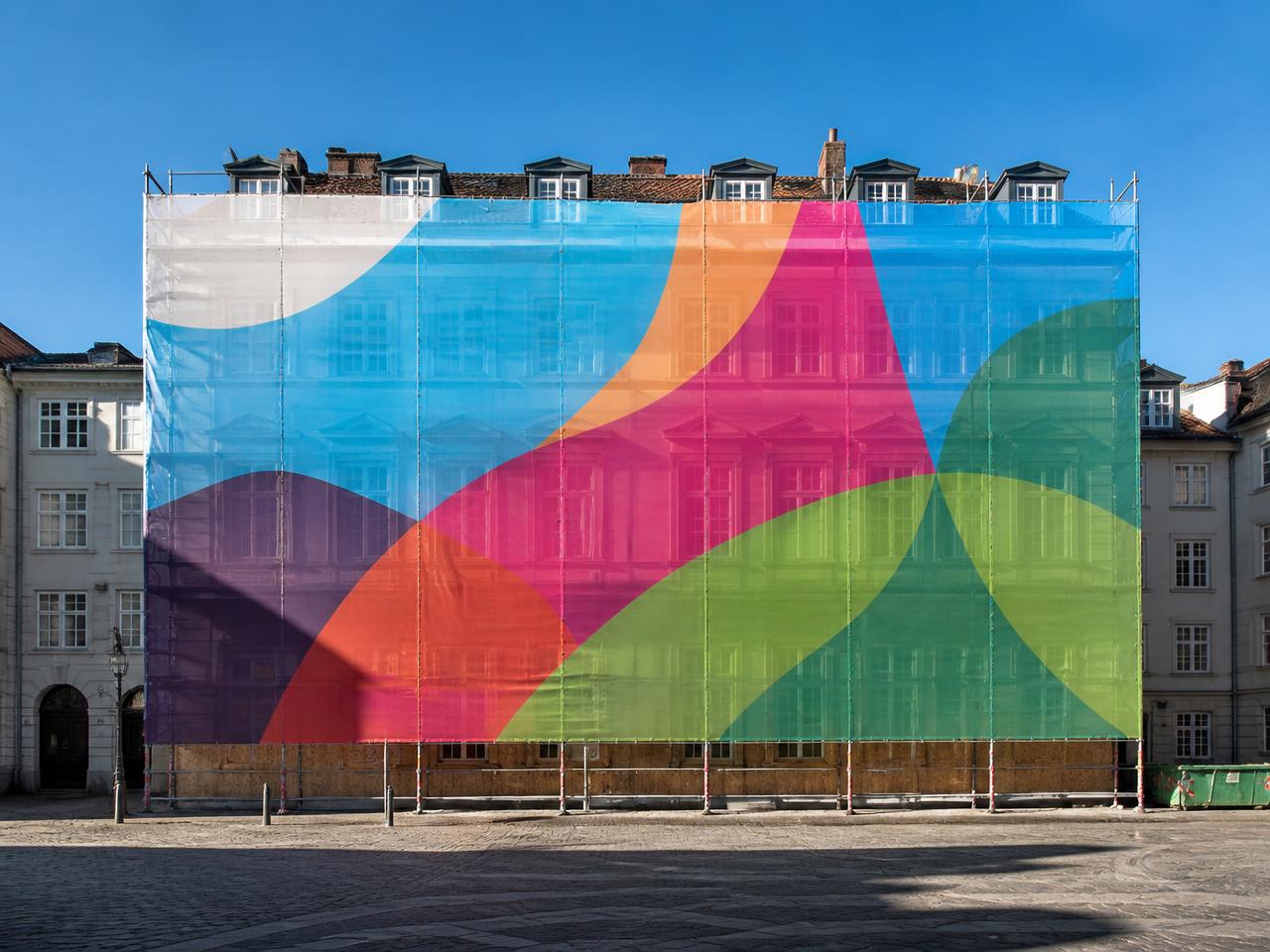 Stilladsbanner på facade i dagslys med kraftige fluorescerende farveflader